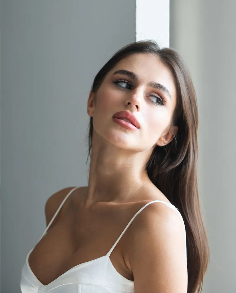 brunette woman leaning head back with white bra