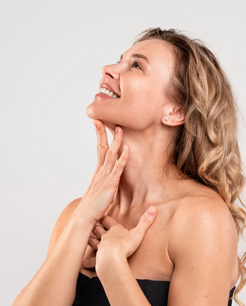 woman with hand under neck looking up smiling