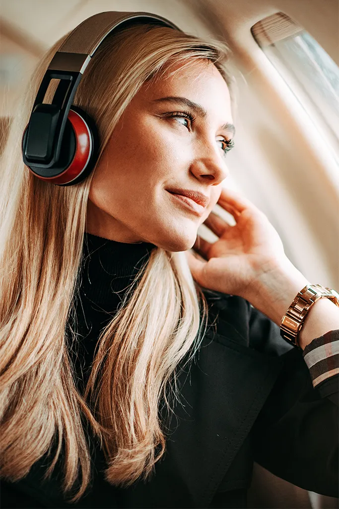 Blonde female wearing headphones on a plane
