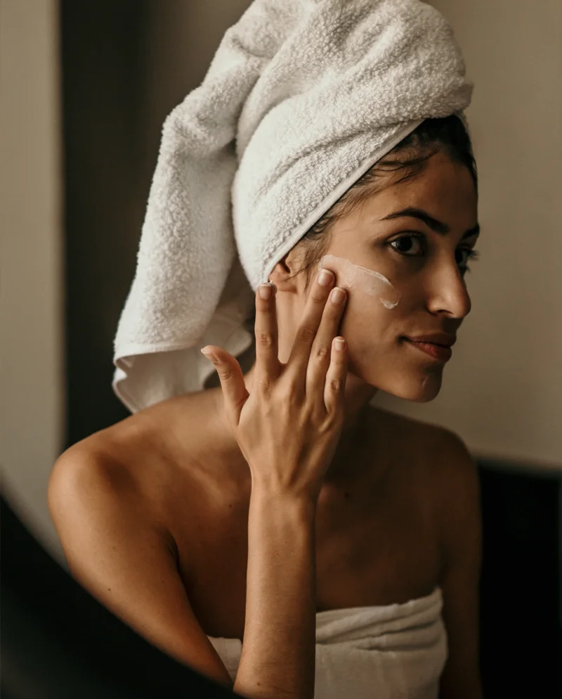 A woman smearing lotion on face