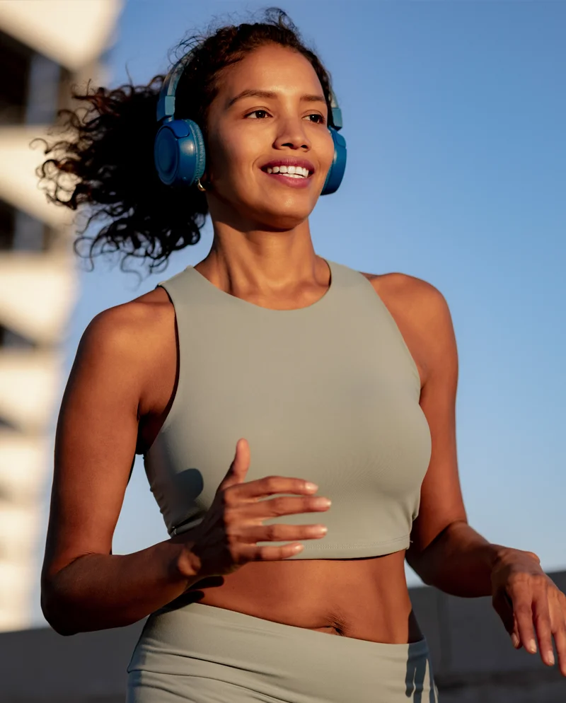 A woman wearing head-phones, jogging